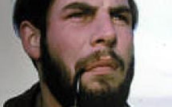 A bearded man smoking a pipe.