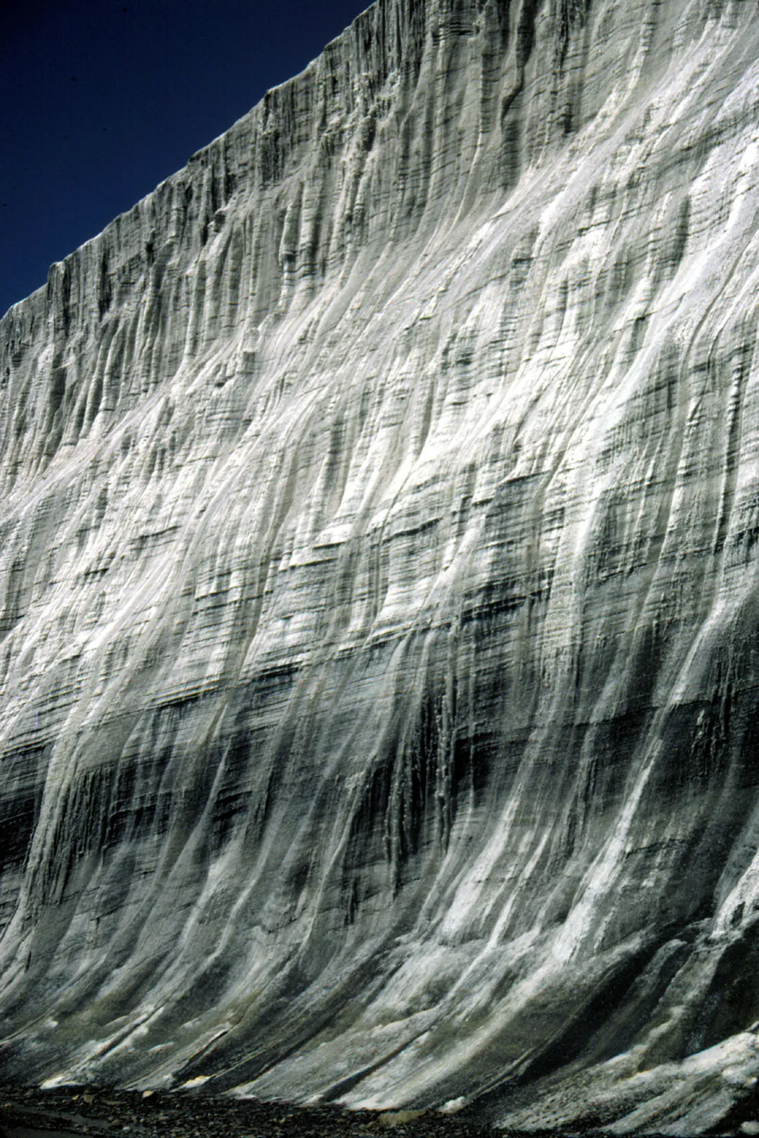 A massive wall of ice under blue skies.