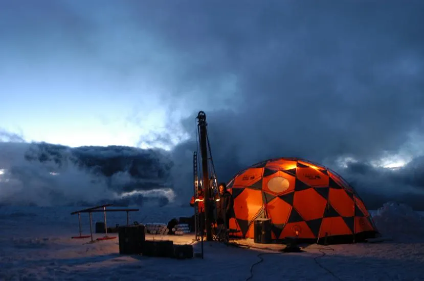 Research site in Quelccaya, Peru. 2003. A shelter is lit up and the outside is dark 