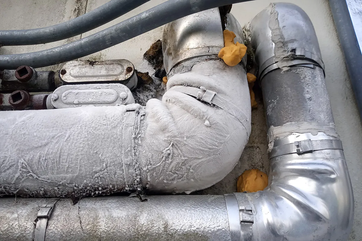 2 gray pipes are installed along a wall and they have become discolored due to insulation deterioration.