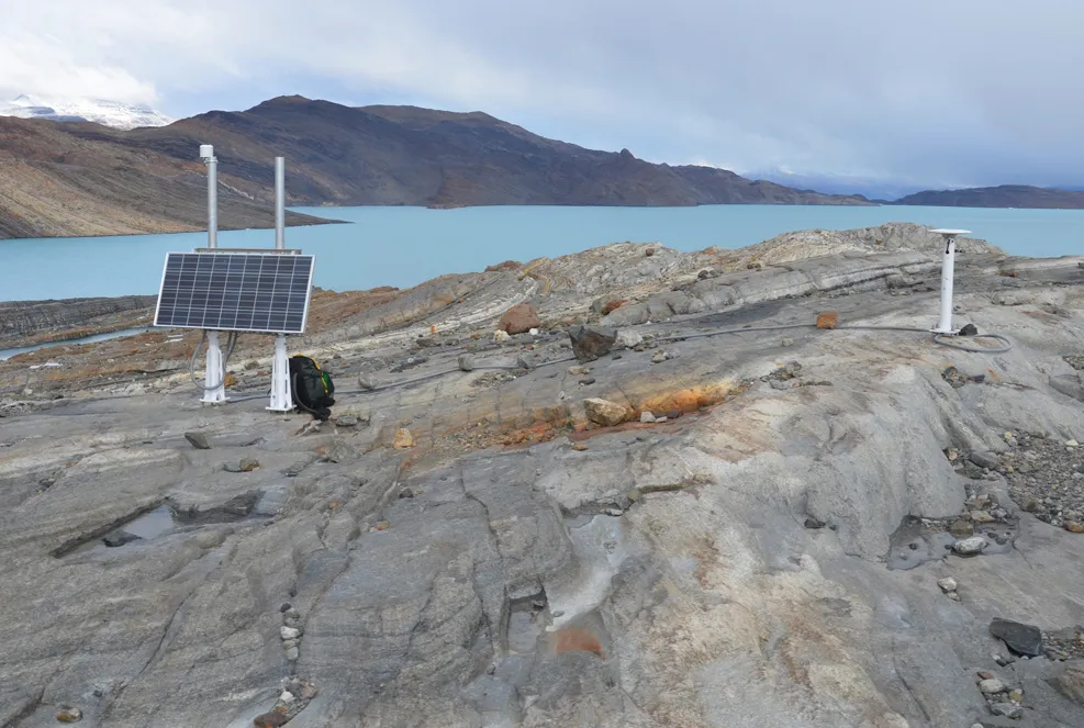 field equipment in front of a lake and mountains in a distance