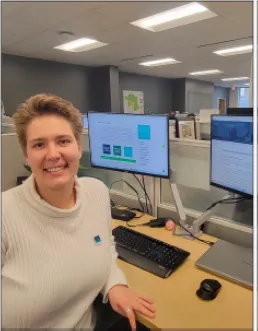 Karina Peggau sitting at a work station with monitors, keyboard and mouse on the desk . 