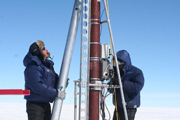 2 researchers use Ice core drilling equipment.