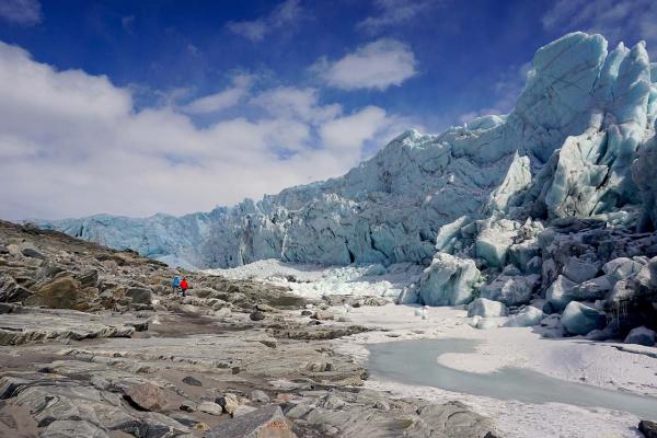 Glacier landscape against a blue sky with white fluffy clouds 