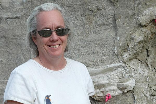 Terry Wilson smiling for a photo in front of a rock