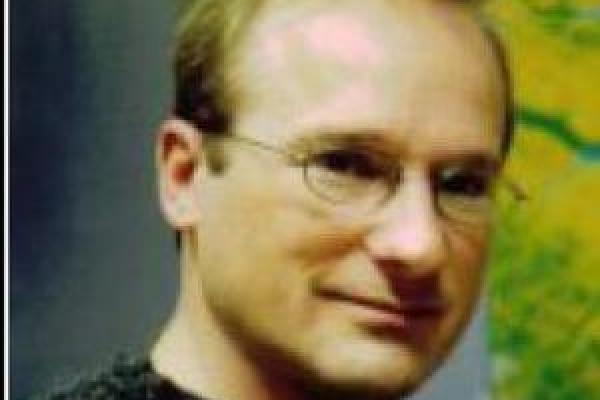 Doug Alsdorf smiling for a photo in a black sweater