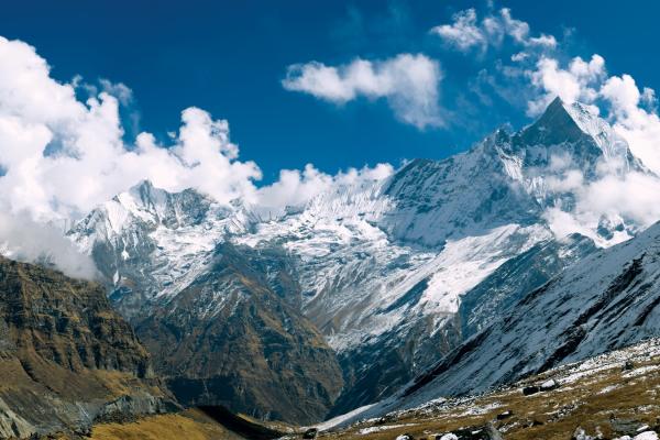 Mountains, some snow covered with blue skies and white clouds 