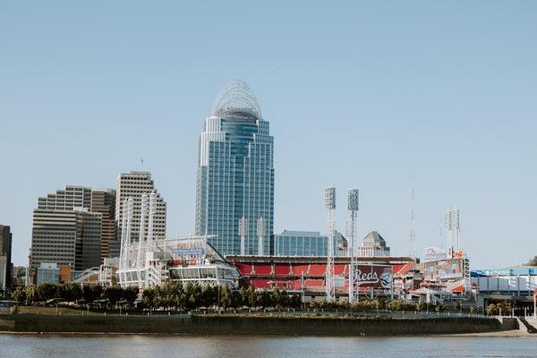 View of downtown Cincinnati during the day with the river, Reds stadium, Great American tower, and other buildings.
