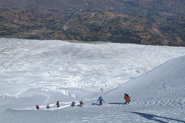 researchers climbing a snow covered scope
