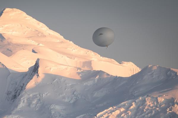 Balloon flying in the sky backdrop of snow covered mountain