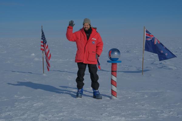 Karsten standing and waving at the South Pole