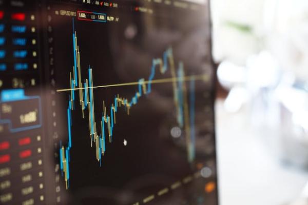 Close-up Photo of Monitor with stock chart on it.