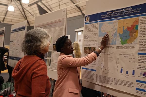 An undergraduate student presenting her research poster.
