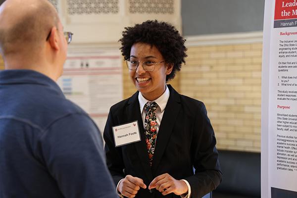 An undergraduate student presenting his research poster.