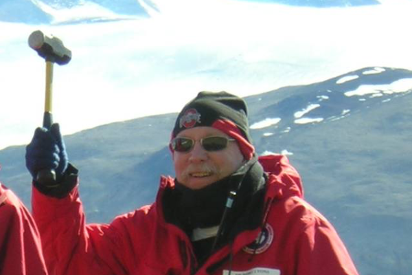 Berry Lyons in Antarctica holding up a mallet