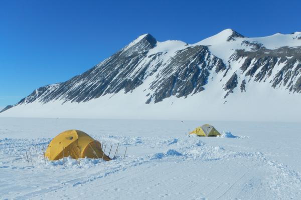 Two tents with mountains in the background