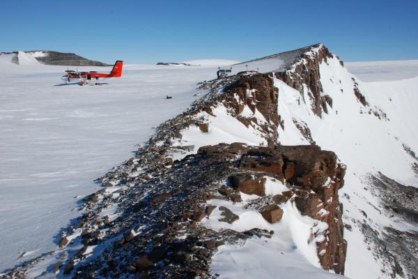 Landscape with rock outcrop, glacier, and airplane