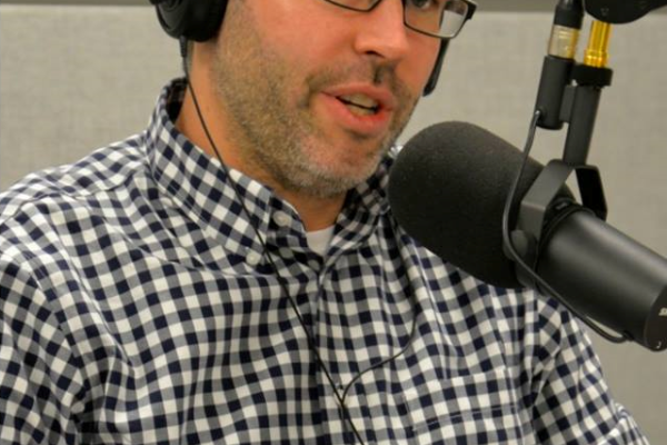 Jason wearing headphones talking into a microphone