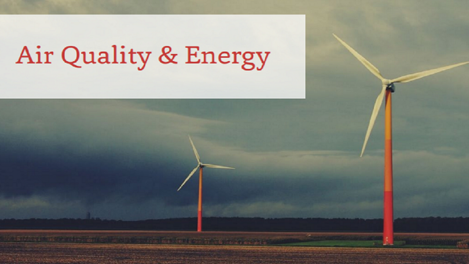 Two windmills on farmland in front of a stormy sky with the text 'Air Quality and Energy'
