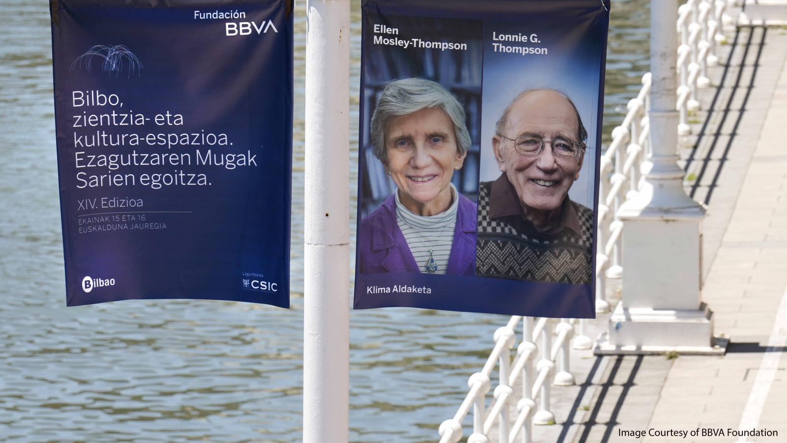 Lonnie Thompson and Ellen Mosely-Thompson images on flags on bridge with water background