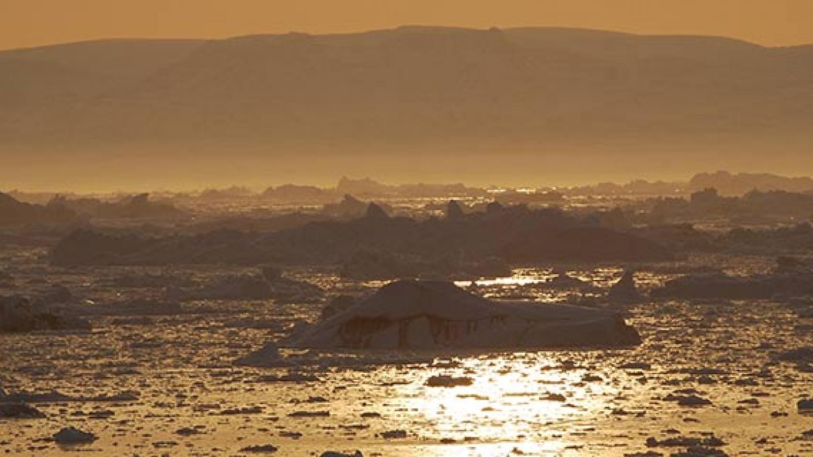 Sunset over icebergs in Disko Bay, Greenland.