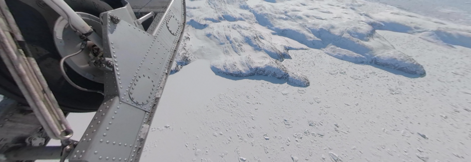 plane flying over ice, ocean, and rock