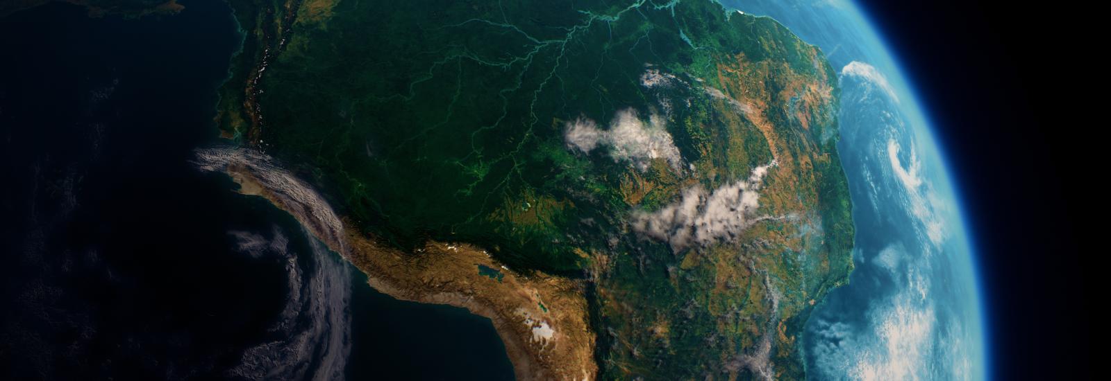 Satellite view of South America with visible lush greenery and cloud formations over the continent, set against the backdrop of Earth's curvature.
