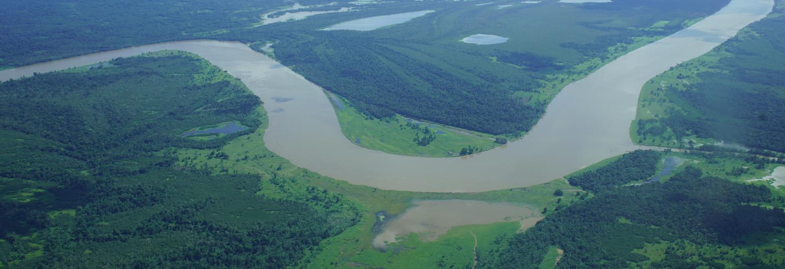 Aerial  of a large river winding in green valley