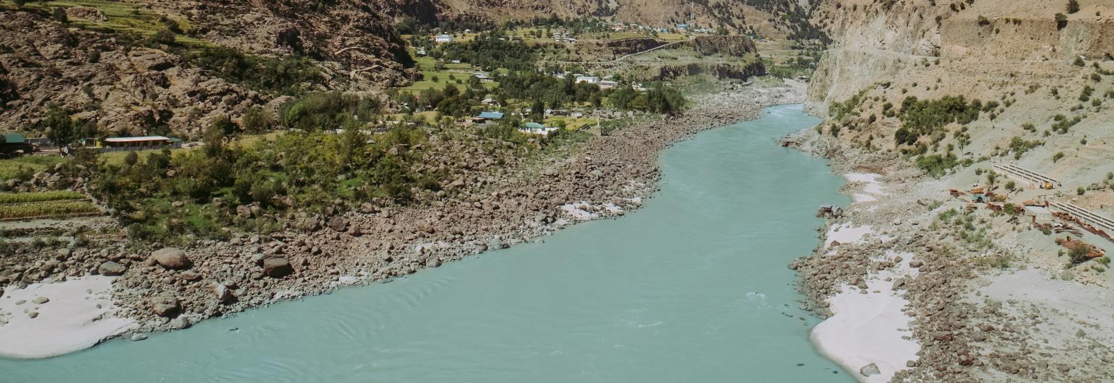 A river flowing between mountains under blue skies.