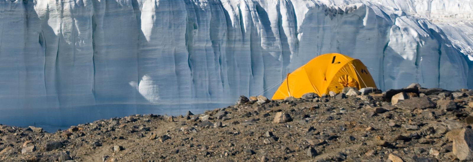 Remote Sensing Lab. A yellow tent is placed beside a large glacier