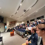 A crowd sitting in an auditorium.
