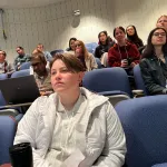 A crowd sitting in an auditorium.