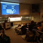 Heidi Roop speaking to an audience in the auditorium.