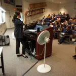 Heidi Roop speaking to an audience in the auditorium.