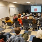 Two people speaking to an audience.