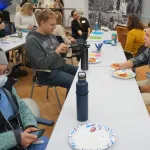 A group seated having lunch and chatting.