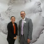 Heidi Roop and Jason Cervenec in front of a large map.