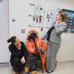 Heidi Roop seated and Karina Peggau standing both posing as if in thought.
