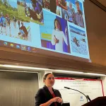 Heidi Roop presenting at the podium.