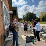 A group standing outside eating pizza