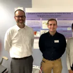 Three people posing in front of a research poster at the Byrd Center