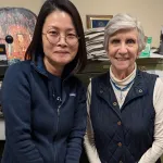 Two people indoors posing for a picture and smiling.