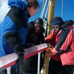 Dr. Lonnie Thompson and two other scientists hold an ice core at the summit of Quelccaya in 2003.