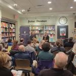 two people seated up front speaking to an audience in a bookstore.