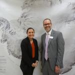Heidi Roop and Jason Cervenec in front of a large map.