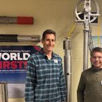 Two individuals standing in front of a poster titled "World First" by the Ice Core Paleoclimatology Group at the Byrd Polar and Climate Research Center, The Ohio State University.